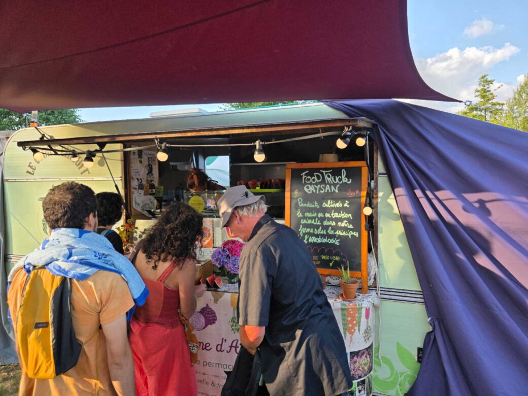Des personne attendent devant Un food Truck paysan au Rêve de l'Aborigène